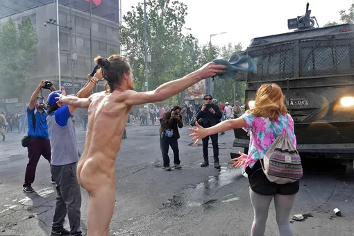 Demonstrators clash with riot police in Santiago, on October 19, 2019. — Chile's president declared a state of emergency in Santiago Friday night and gave the military responsibility for security after a day of violent protests over an increase in the price of metro tickets.