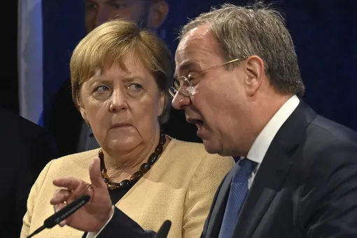 German Chancellor Angela Merkel (L) looks left as Armin Laschet (R), chairman and chancellor candidate of Germany's conservative Christian Democratic Union (CDU) party, gesticulates and addresses the campaign rally in Stralsund, north-eastern Germany, on September 21, 2021, days before general elections. (Photo by John MACDOUGALL / AFP) (Photo by JOHN MACDOUGALL/AFP via Getty Images)