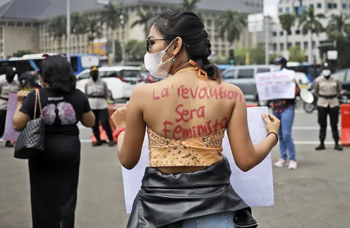 Активистка на женском марше в Джакарте, Индонезия. На спине у нее написано слоган: «Революция будет феминистской»