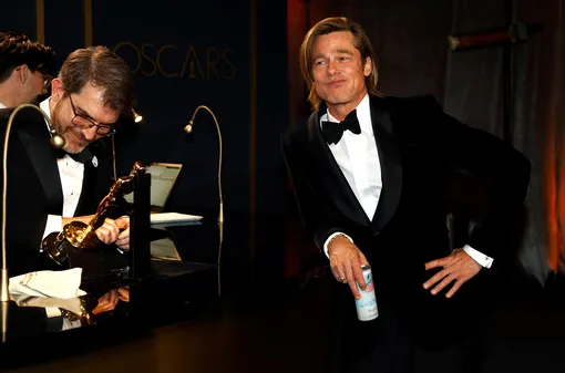 Счастливый обладатель «Оскара» Брэд Питт ждет гравировки своей статуэтки, попивая газировки на губернаторском балу
