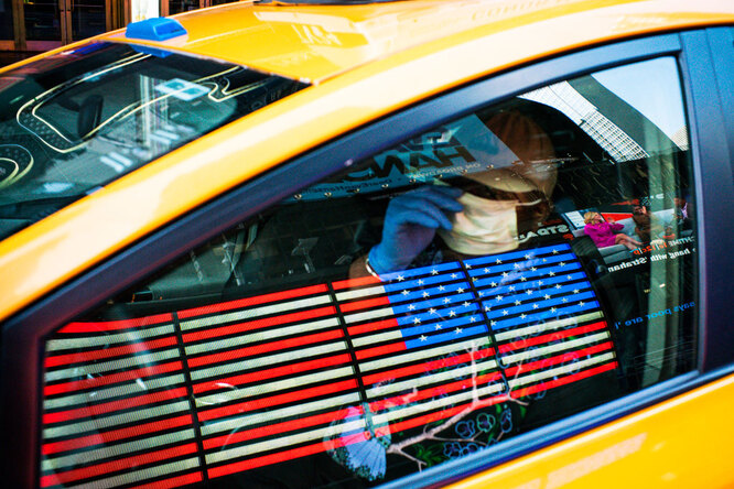 Водитель такси в защитной маске проезжает по Таймс-Сквер, Нью-Йорк, 26 марта 2020