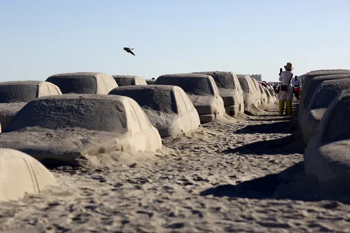Люди смотрят на песчаные скульптуры, изображающие стоящие в пробке автомобили. Скульптурная группа называется «Орден важности», а создал ее художник Леандро Эрлих в рамках Недели искусства в Майами. 3 декабря 2019