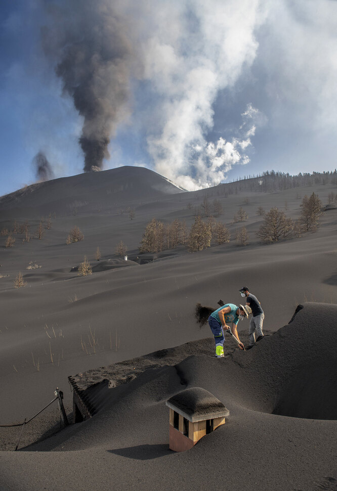 Жители деревни Ла-Манча на острове Пальма (Канары) убирают пепел после извержения вулкана Кумбре-Вьеха.