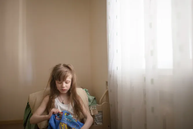 Алина (6 лет, неслышащая, страдает аутизмом) одевается после тихого часа.