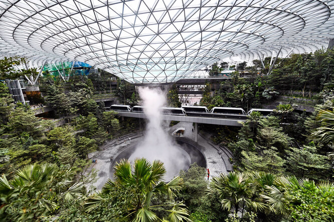В международном аэропорту Чанги в Сингапуре открылся новый комплекс Jewel Changi Airport («Жемчужина»), который представляет собой десятиуровневое строение c парками, пешеходными тропами, магазинами, аттракционами, отелем и главным объектом — водопадом Rain Vortex («Дождевой вихрь»)