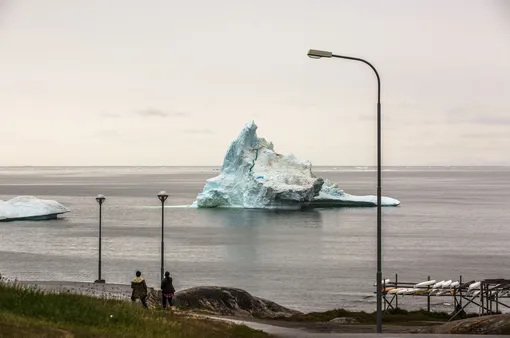 Тающий асберг в порту города Илулиссат на западном побережье Гренландии