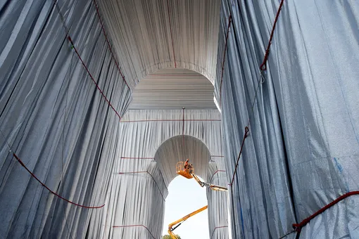Workers install a shimmering wrapper to envelop the Arc de Triomphe monument, a posthumous installation known as «L'Arc de Triomphe, Wrapped» conceived by the late artists Christo and Jeanne-Claude, on the Champs Elysees avenue in Paris, France, September 16, 2021. REUTERS/Gonzalo Fuentes