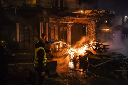 Демонстранты тушат пожар, вспыхнувший во время митина