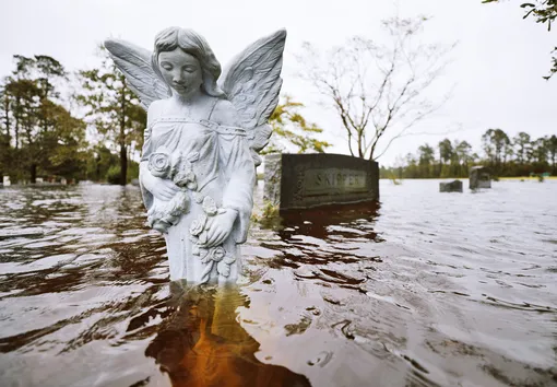 Затопленная статуя ангела на местном кладбище.