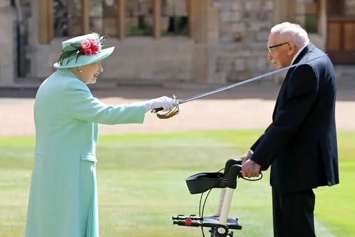 Britain's Queen Elizabeth awards Captain Tom Moore with the insignia of Knight Bachelor at Windsor Castle, in Windsor, Britain July 17, 2020