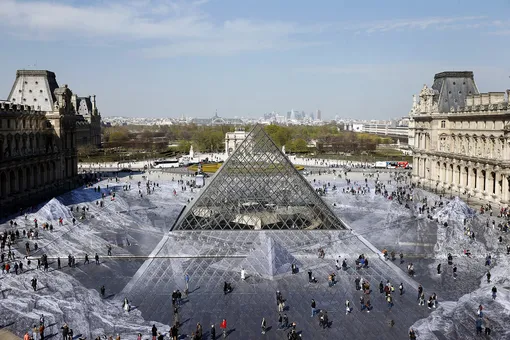 К 30-летию пирамиды Лувра французский фотохудожник Жан Рене (известен как JR) вместе с 400 волонтерами изготовил объемный и невероятно реалистичный коллаж с оптической иллюзией: выглядит так, будто пирамида находится внутри огромного кратера или шахты.
