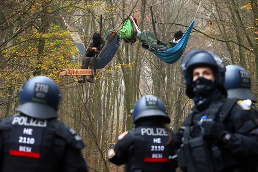 Police officers are seen as demonstrators lie in hammocks hanging from trees during a protest against the extension of the A49 motorway, in a forest near Stadtallendorf, Germany, November 11, 2020. REUTERS/Kai Pfaffenbach