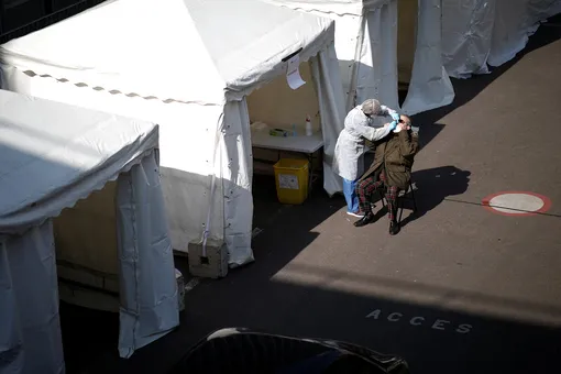 Медик берет анализы на коронавирус в одном из передвижных центров диагностики в Париже
