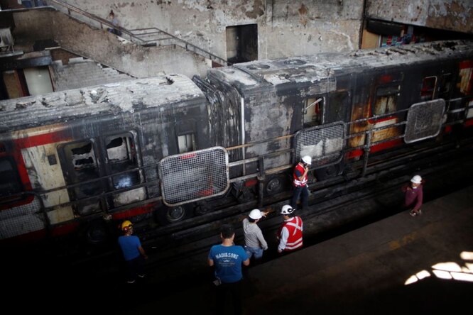 Locals help in cleaning of the Metro of Santiago subway at Station San Pablo «Saint Paul» is seen after it was burned following demonstrations against a rise in metro fares turned into act of violence in Santiago, Chile on October 20, 2019. (Photo by Sebastian Brogca/Anadolu Agency via Getty Images