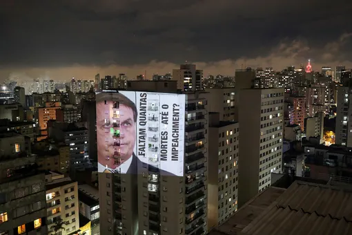 Фото президента Бразилии Жаира Болсонару с подписью «Сколько смертей до импичмента?», спроецированное на здание во время протеста против его политики в отношении коронавируса и кризиса здравоохранения, Сан-Паулу , Бразилия, 15 января 2021 г.