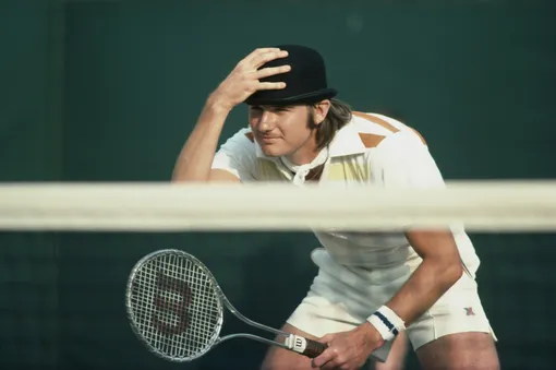 Jimmy Connors clowns and jokes with the spectators by wearing a bowler hat during a Men's Doubles match with partner Ilie Nastase at the Wimbledon Lawn Tennis Championship on 1st July 1976 at the All England Lawn Tennis and Croquet Club in Wimbledon in London, England. (Photo by