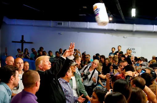 U.S. President Donald Trump throws rolls of paper towels into a crowd of local residents affected by Hurricane Maria as he visits Calgary Chapel in San Juan, Puerto Rico, U.S., October 3, 2017. Jonathan Ernst: «During an afternoon visit to Puerto Rico for President Trump to survey damage from Hurricane Maria and greet some of its victims, Trump made a stop at a church where food and supplies were being distributed. Among the items were paper towels and Trump, apparently caught up in the moment, decided to distribute some of the rolls.» REUTERS/Jonathan Ernst