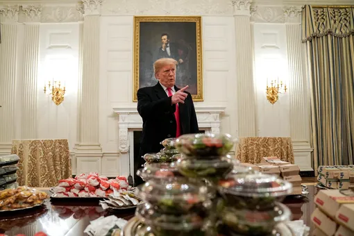U.S. President Donald Trump speaks in front of fast food provided for the 2018 College Football Playoff National Champion Clemson Tigers due to the partial government shutdown in the State Dining Room of the White House in Washington, U.S., January 14, 2019. REUTERS/Joshua Roberts T