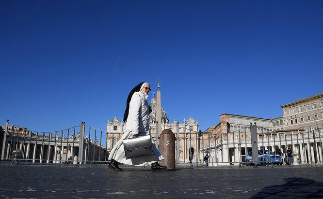 A nun walks next to an empty St. Peter's Square, on the third day of an unprecedented lockdown across of all Italy imposed to slow the outbreak of coronavirus, as seen from Rome, Italy, March 12, 2020. REUTERS/Alberto Lingria TPX IMAGES OF THE DAY