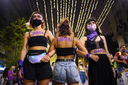 Participants with the word «Harta» on their bodies, link arms as they mark International Women's Day at Avenida 18 de Julio in downtown Montevideo, Uruguay March 8, 2021. The word is a term to say exhausted or «had enough» but used by women. REUTERS/Mariana Greif TPX IMAGES OF THE DAY
