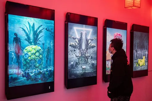 Цифровые картины американского художника Beeple на выставке криптоискусства «Virtual Niche: Have You Ever Seen Memes in the Mirror?» в Пекине 26 марта 2021 года.