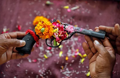 Police officers hold a revolver as they offer prayers to their weapons as part of a ritual at their headquarters on the occasion of Dussehra, or Vijaya Dashami, festival in Ahmedabad, India, October 8, 2019. REUTERS/Amit Dave TPX IMAGES OF THE DAY
