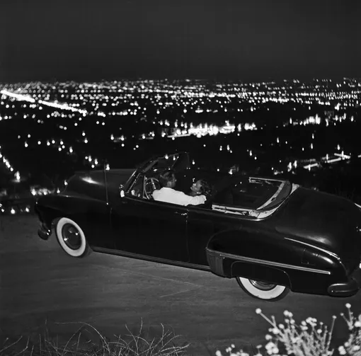 A couple in their car on Mulholland Drive overlooking the city at night on June 7 1951 in Los Angeles California. (Photo by Earl Leaf/Michael Ochs Archive/Getty Images)
