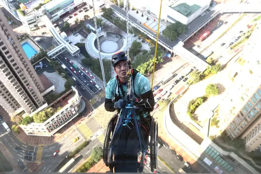 Прикованный к инвалидной коляске экс-альпинист из Гонконга поднялся на небоскреб, чтобы собрать средства пациентам с травмами позвоночника