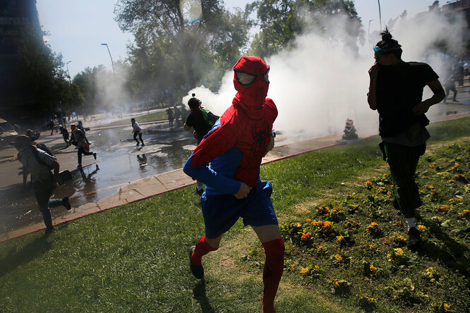 A demonstrator dressed as Spiderman runs from tear gas during a protest against Chile's state economic model in Santiago October 20, 2019.