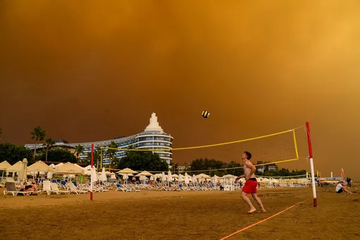 Dark smoke drifts over a hotel complex during a massive forest fire which engulfed a Mediterranean resort region on Turkey's southern coast near the town of Manavgat, on July 29, 2021. — At least three people were reported dead on July 29, 2021 and more than 100 injured as firefighters battled blazes engulfing a Mediterranean resort region on Turkey's southern coast. Officials also launched an investigation into suspicions that the fires that broke out Wednesday in four locations to the east of the tourist hotspot Antalya were the result of arson.