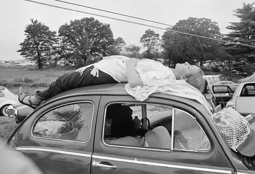 Aug. 16, 1969 file photo, a young woman naps on top of her car while trying to reach the Woodstock Music and Art Festival in Bethel, N.Y. Organizers had sold 186,000 tickets; ultimately an estimated 400,000 people showed up for the festival on a 600-acre parcel of farmland. (Фото: AP/East News)