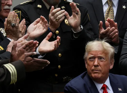 U.S. President Donald Trump listens to applause after signing an executive order on police reform during a ceremony in the Rose Garden at the White House in Washington, U.S., June 16, 2020. REUTERS/Leah Millis/File Photo