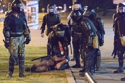 Протестующий лежит на земле перед сотрудниками ОМОНа