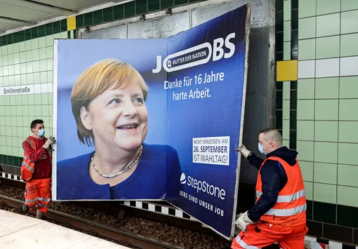 Workers remove an advertisement showing German Chancellor Angela Merkel with a slogan that reads «Mother of Nation — Thanks For 16 Years of Hard Work» before the upcoming state elections in Hamburg, Germany September 24, 2021. REUTERS/Fabian Bimmer