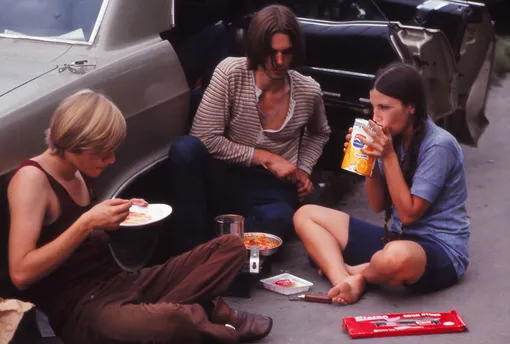 Young people relaxing and eating on their way to the Woodstock Music Festival, New York, US, August 1969.