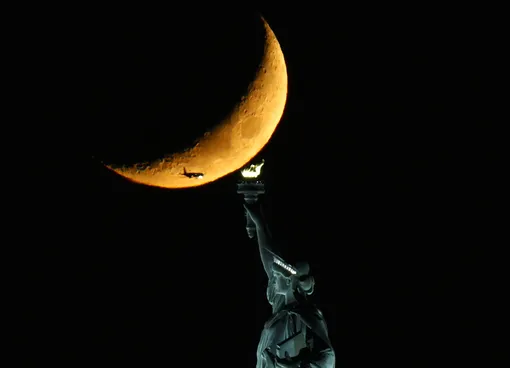 Растущая луна на фоне Статуи Свободы, Нью-Йорк, 8 ноября 2021 года. A Waxing Crescent Moon sets behind The Statue of Liberty on Monday, November 08, 2021 in New York City.8 Nov 2021