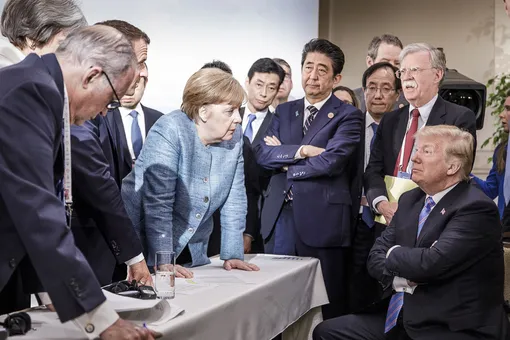 CHARLEVOIX, CANADA — JUNE 9: In this photo provided by the German Government Press Office (BPA), German Chancellor Angela Merkel deliberates with US president Donald Trump on the sidelines of the official agenda on the second day of the G7 summit on June 9, 2018 in Charlevoix, Canada. Also pictured are (L-R) Larry Kudlow, director of the US National Economic Council, Theresa May, UK prime minister, Emmanuel Macron, French president, Angela Merkel, Yasutoshi Nishimura, Japanese deputy chief cabinet secretary, Shinzo Abe, Japan prime minister, Kazuyuki Yamazaki, Japanese senior deputy minister for foreign affairs, John Bolton, US national security adviser, and Donald Trump. Canada are hosting the leaders of the UK, Italy, the US, France, Germany and Japan for the two day summit. (Photo by Jesco Denzel /Bundesregierung via Getty Images)