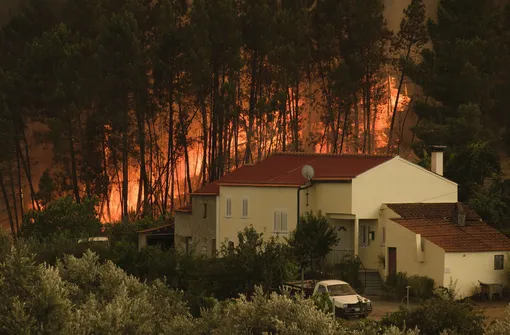 The fire advance at the village of Chaveira, near Macao, in central Portugal on Monday, July 22, 2019. More than 1,000 firefighters are battling a major wildfire amid scorching temperatures in Portugal, where forest blazes wreak destruction every summer. About 90% of the fire area in the Castelo Branco district, 200 kilometers (about 125 miles) northeast of the capital Lisbon, has been brought under control during cooler overnight temperatures, according to a local Civil Protection Agency commander.