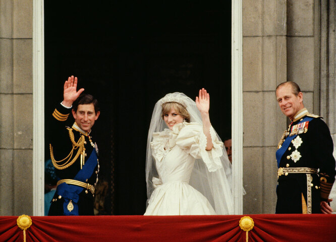 LONDON, UNITED KINGDOM — JULY 29: Prince Charles And Princess Diana Waving From The Balcony Of Buckingham Palace. They Are Accompanied By Prince Philip. The Princess Is Wearing A Dress Designed By David And Elizabeth Emanuel.