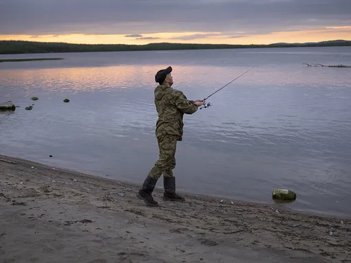 Aleksey fishing by the river, in Nikel, Russia.