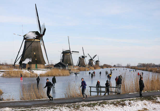 Первые за несколько лет заморозки частично заморозили каналы в голландских городах. На фото жители деревни Киндердейк катаются на коньках.