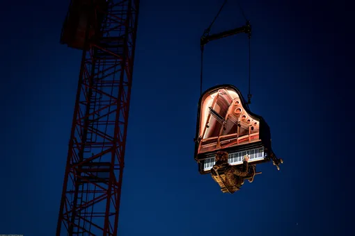 Swiss pianist and composer Alain Roche performs «Chantier» suspended in the air with his grand piano under a moving crane at dawn on August 16, 2019 during the 20th «Jeux du Castrum», a multidisciplinary festival that takes place until August 18, 2019 in Yverdon-les-Bains.