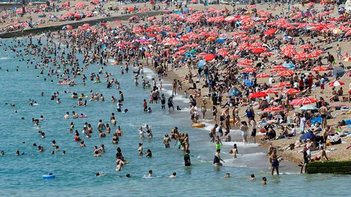 Люди пытаются освежиться на пляже в Британии.