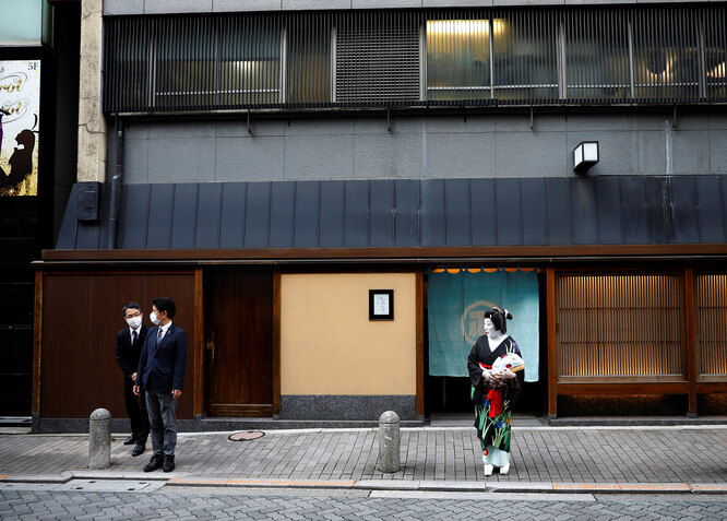 Сотрудники ресторана Asada в защитных масках стоят на улице с гейшей Икуко в ожидании ее коллеги.