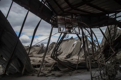 LAUREL, PHILIPPINES — JANUARY 14: The roof a basketball gymnasium, destroyed by volcanic ash from Taal Volcano's eruption, is seen on January 14, 2020 in Laurel, Batangas province, Philippines. The Philippine Institute of Volcanology and Seismology raised the alert level to four out of five, warning that a hazardous eruption could take place anytime, as authorities have evacuated tens of thousands of people from the area. An estimated $10 million worth of crops and livestock have been damaged by the on-going eruption, according to the country's agriculture department. (Photo by Ezra Acayan/Getty Images)