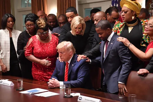 — US President Donald Trump (C) stands in a prayer circle with African-American leaders in the Cabinet Room of the White House in Washington, DC, on February 27, 2020. (Photo by Nicholas Kamm / AFP) (Photo by NICHOLAS KAMM/AFP via Getty Images)