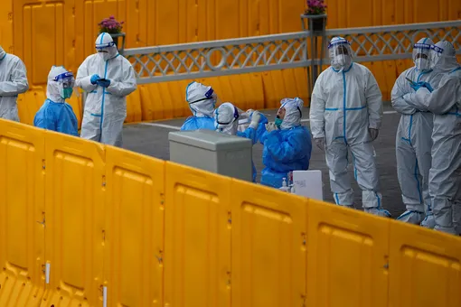 Policemen and staff workers get tested for the coronavirus disease (COVID-19) at a makeshift nucleic acid testing centre inside barriers of an area under lockdown amid the coronavirus disease (COVID-19) pandemic, in Shanghai, China March 24, 2022.