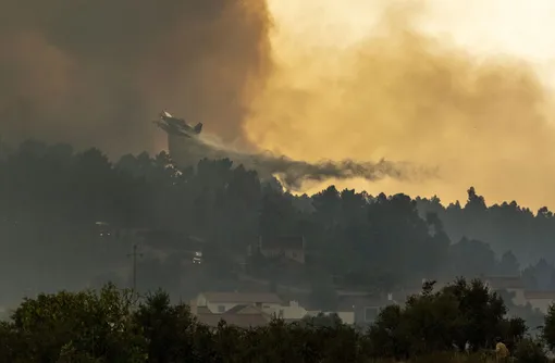 An airplane operates over a fire at the village of Chaveira, near Macao, in central Portugal on Monday, July 22, 2019. More than 1,000 firefighters are battling a major wildfire amid scorching temperatures in Portugal, where forest blazes wreak destruction every summer. About 90% of the fire area in the Castelo Branco district, 200 kilometers (about 125 miles) northeast of the capital Lisbon, has been brought under control during cooler overnight temperatures, according to a local Civil Protection Agency commander.