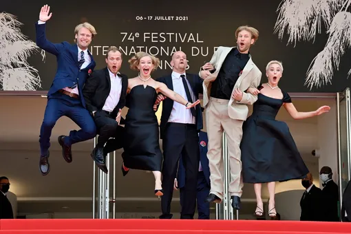 Semyon Serzin, Russian actor Yuriy Borisov, Russian actress Yuliya Peresild, Russian actor Yuri Kolokolnikov, Russian actor Ivan Dorn and Russian actress Chulpan Khamatova jump as they arrive for the screening of the film «Petrov's Flu» at the 74th edition of the Cannes Film Festival in Cannes, southern France, on July 12, 2021. (Photo by John MacDougall / AFP / Getty Images