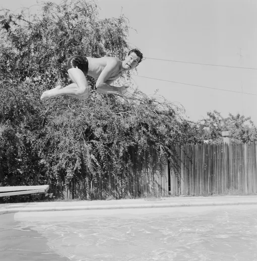 Джонни Карсон, ведущий «Шоу Джонни Карсона на CBS», прыгает в бассейн своего дома в Лос-Анджелесе, штат Калифорния, 5 июля 1956 года